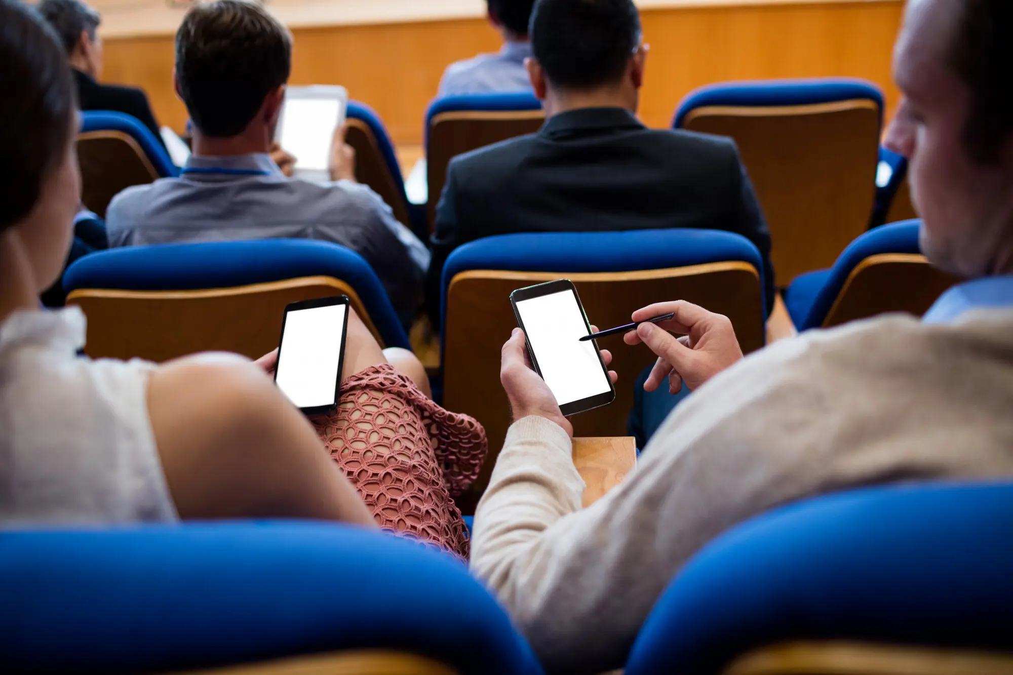 Führungskräfte, die mithilfe eines Mobiltelefons an einer Geschäftsbesprechung teilnehmen, praxisnah und nachvollziehbar.