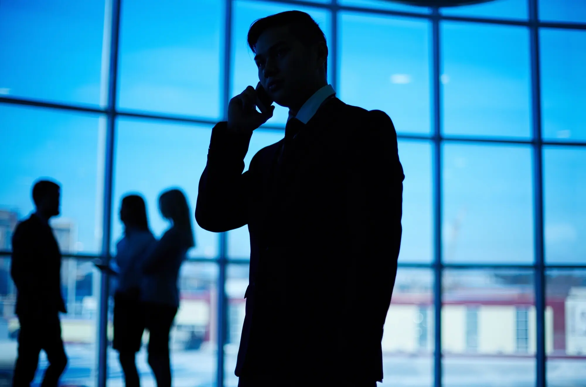 Nahaufnahme der Silhouette eines Mannes, der am Telefon spricht.
